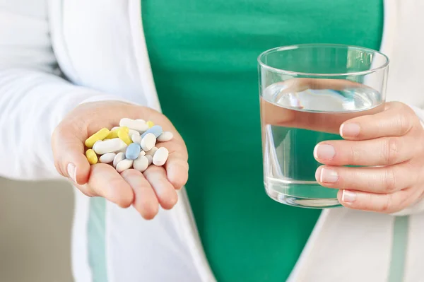 Strzał Nierozpoznawalnej Młodej Kobiety Dużą Ilością Tabletek Szklanką Wody — Zdjęcie stockowe