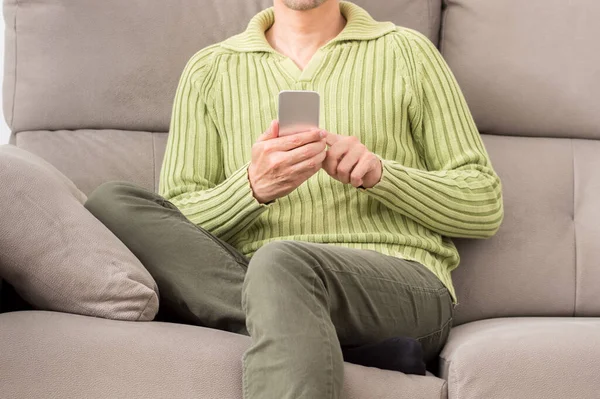 Widok Przodu Nogi Człowieka Patrząc Telefon Siedzi Kanapie Salonie Domu — Zdjęcie stockowe