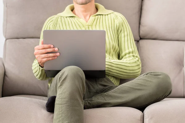 冬日里 一个人坐在室内客厅的沙发上 他的腿看上去像一台笔记本电脑 — 图库照片