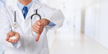 Hastanedeki erkek doktorun elinde şekerin baş parmağıyla uzayın fotokopisini çekerken görüntüsü.