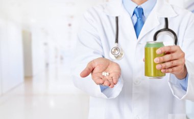 Erkek bir doktorun elinde soda şişesi ve hastanede sakarin tutarken görüntüsü.