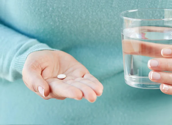 錠剤と水のガラスを示す認識できない若い女性の手のショット — ストック写真
