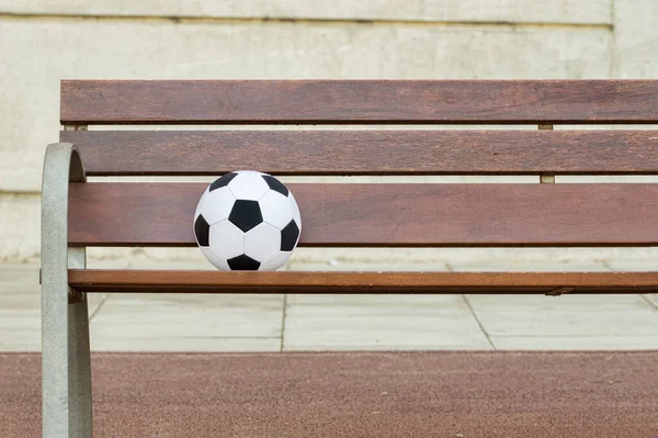壁に対して 通りを失うサッカーボールを持つ単一の木製のベンチ スペースをコピー — ストック写真