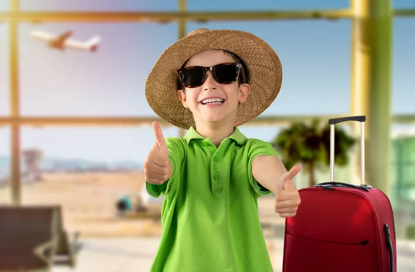 在机场 与戴着帽子和太阳镜 竖起大拇指的快乐孩子亲密接触 — 图库照片