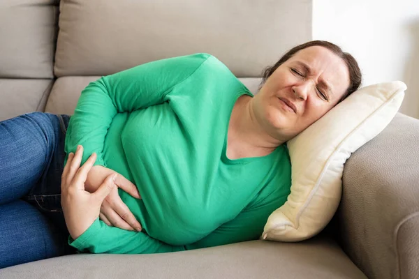 Frau Hat Bauchschmerzen Wenn Sie Hause Auf Dem Sofa Liegt — Stockfoto