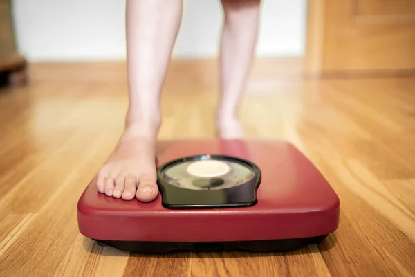 女の子の閉鎖は体重計で体重を測定します — ストック写真
