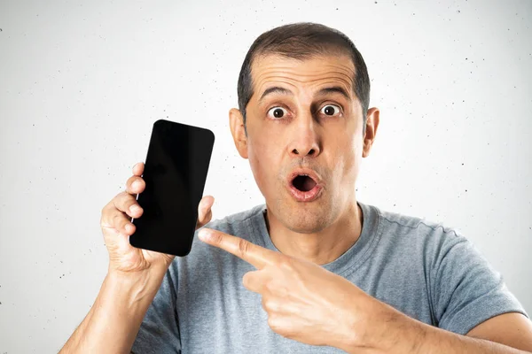 Man Using Smartphone Isolated Concrete Wall Background Surprise Face Pointing — Stock Photo, Image