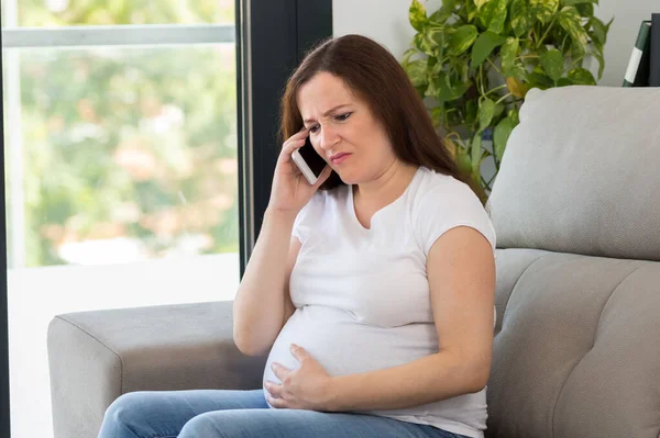 Schot Van Een Pijnlijke Zwangere Vrouw Die Dokter Thuis Belt — Stockfoto