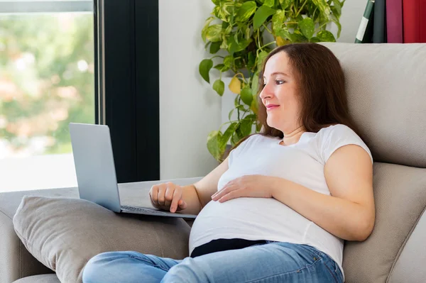 自宅でノートパソコンを使って妊娠中の女性のショット — ストック写真