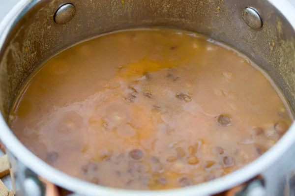 スプーンと様々な食材を使用した素朴なキッチンテーブルの背景にレンズ豆スープとボウル 全体構成 — ストック写真