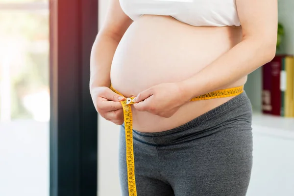Fotografía Recortada Una Mujer Embarazada Midiendo Vientre Casa —  Fotos de Stock
