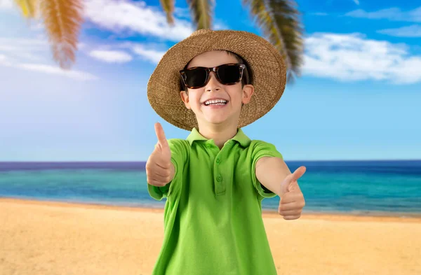 Szczęśliwe Dziecko Kapeluszu Okularach Przeciwsłonecznych Trzymające Kciuki Tropikalnej Plaży — Zdjęcie stockowe