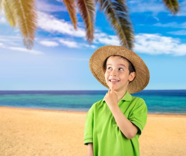 Tropik plajda eli çenesinde koyu renk saçlı bir çocuk soru sormayı, düşünceli ifadeyi düşünüyor. Şüphe kavramı ve yana bakma.