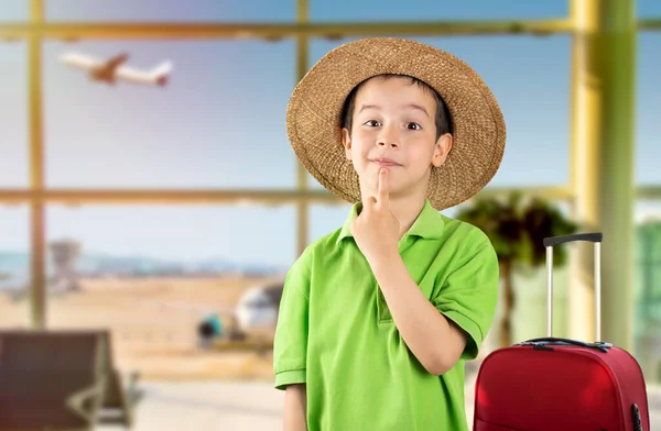 暗い髪の少年は緑のTシャツと帽子を空港で手にあごの質問 思慮深い表現について考えて身に着けている 思慮深い顔で微笑んだ 疑いの概念 — ストック写真