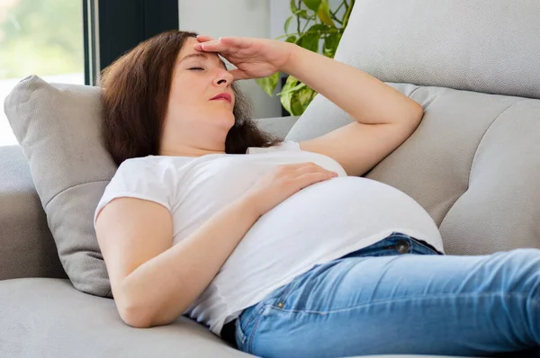 Gravid Kvinna Med Hand Pannan Lider Huvudvärk Liggande Soffa Vardagsrummet — Stockfoto