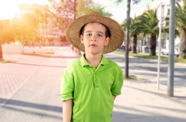 Yorgun bir çocuk, ateşli ve arka planda güneşli.