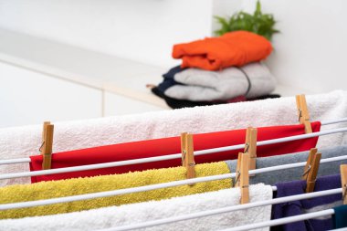 Evdeki kurutma askısına asılı temiz çamaşırları kapatın.