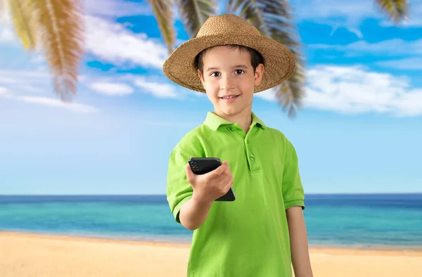 Mały Chłopiec Pomocą Smartfona Patrząc Aparat Szczęśliwą Twarzą Kapeluszem Stojący — Zdjęcie stockowe