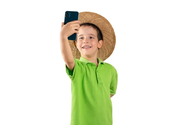 白い背景の上にスマートフォンによって自信を持って作る帽子と笑顔で白人の小さな男の子のショット — ストック写真