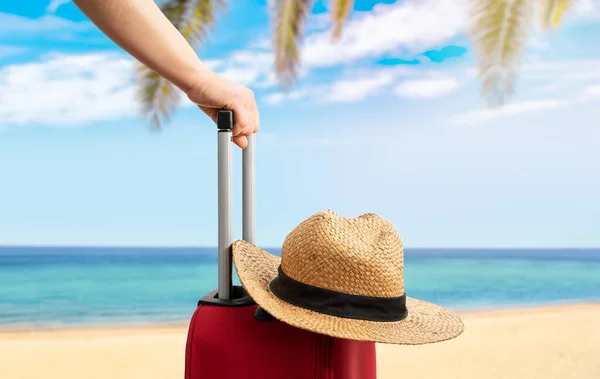 站在热带海滨 头戴红色手提箱和帽子的妇女 旅游概念 — 图库照片