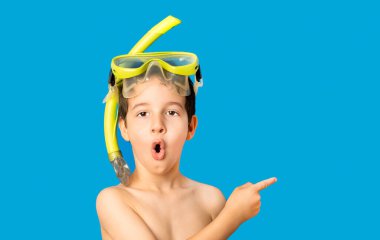 Maskeli ve şnorkelli bir çocuk. Şnorkelleme, yüzme, tatil konsepti mavi arka planda izole edilmiş. Kafkas erkek modeli.