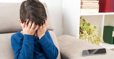 Çocukluk kabadayılığı, depresyon stresi ya da oda sıkıntısı için koltuk konseptinde oturan kafası karışık sorunlu bir çocuk.