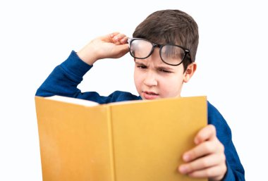 Evde kitap okumaya çalışan çocuk göz yorgunluğu çekiyor.