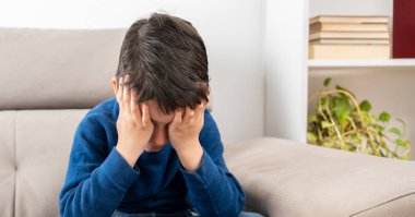 Çocukluk zorbalığı, depresyon stresi ya da hüsran için koltuk üzerinde oturan kafası karışık sorunlu çocuk.