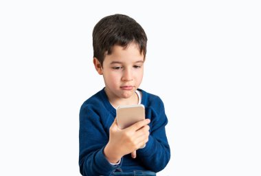 Telefonu olan küçük bir çocuk. Beyaz arka planda akıllı telefonuyla oynayan küçük bir çocuk..