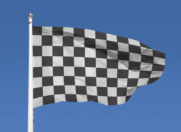 Black white race chequered or checkered flag with metal stick and blue sky background. motorsport and motorcycling racing symbol concept