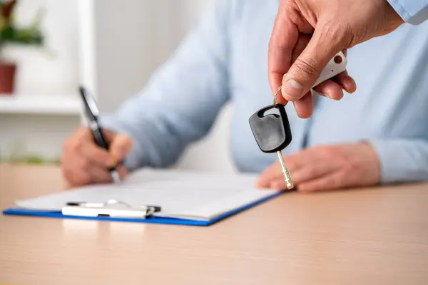 Car loan form or lease application document. Woman signing paper contract to sell premium vehicle. Buyer or dealer in agency. Auto insurance or finance paperwork. Deal, policy or financial agreement.