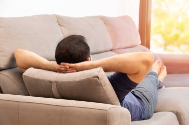 Evdeki kanepesinde dinlenen tanınmayan bir gencin dikiz görüntüsü.