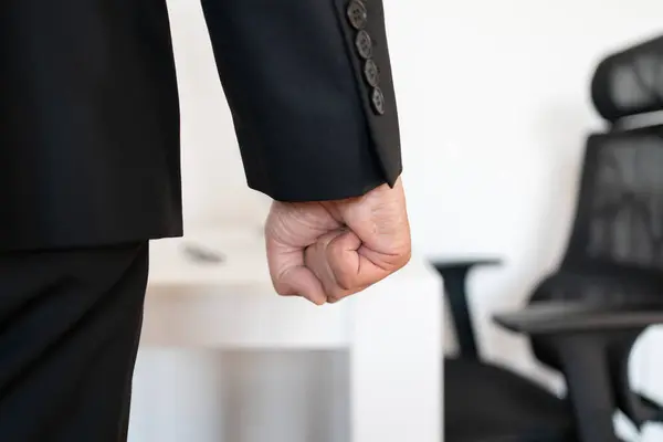 Hand or fist of angry, frustrated and stress businessman in a work office. Corporate employee upset, furious and conflict while feeling violence, anger or fight at a workplace after conflict at work