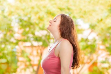 Bir parkta veya ormanda temiz hava soluan rahat kadın