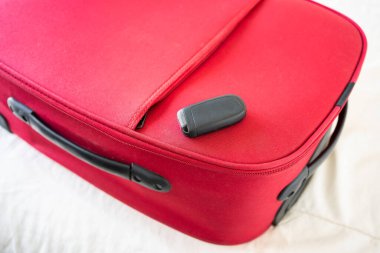 Kırmızı valiz konseptinde araba anahtarı.