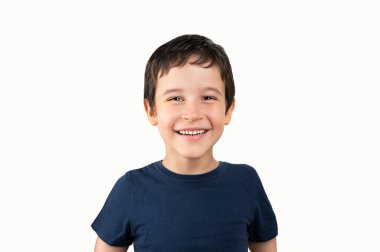 Yüzünde mutlu ve havalı bir gülümsemeyle izole edilmiş beyaz arka plan üzerinde duran sıradan bir tişört giyen küçük çocuk. Şanslı kişi.