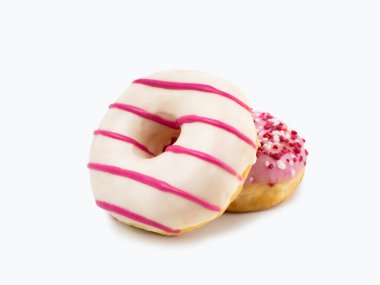 Beyaz çikolata ve beyaz arkaplanlı pembe çizgili iki çörek.