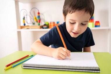 Çocuk elinin fotoğrafı turuncu bir kalem çizer.