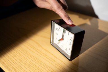 El, evde yataktan kalktıktan sonra çalar saatini arar.