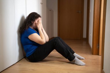 Kafası çalışan sorunlu bir kadın yerde oturmuş kabadayılık, depresyon stresi ya da iş yerindeki hayal kırıklığıyla uğraşıyor.