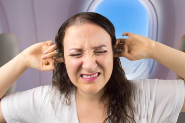 Uçaktan inerken kulaklığı olan bir kadın..