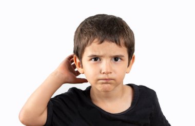 İzole edilmiş bir arka planda, ağzı kulaklarında gülümseyen bir çocuk dedikoduları ve dedikoduları dinliyor. Sağırlık kavramı.