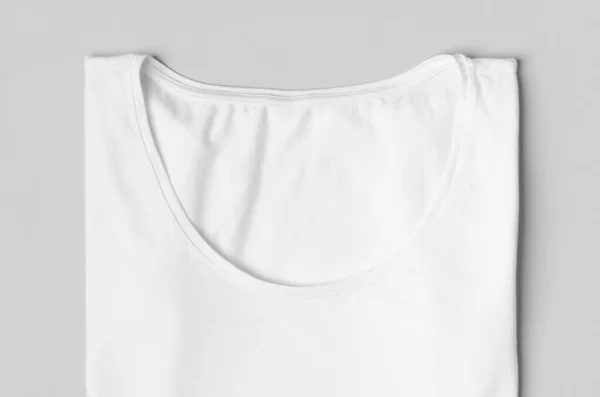 Folded women\'s crew neck t-shirt label mockup, closeup.