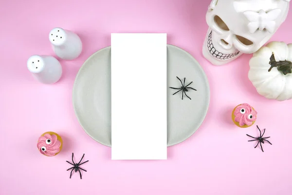 粉红万圣节4X9菜单卡片模型 用白色骷髅 黑蜘蛛和怪异的纸杯蛋糕装饰或处理派对用品的文具 负复制空间 图库图片