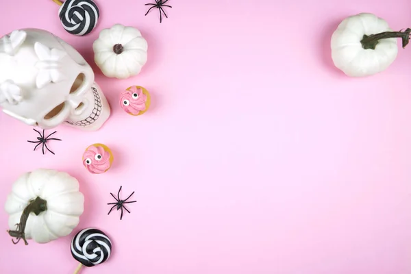 粉色万圣节设计了边界背景 用白色骷髅 黑蜘蛛和恐怖的纸杯蛋糕来捣蛋或捣蛋 负复制空间 免版税图库图片