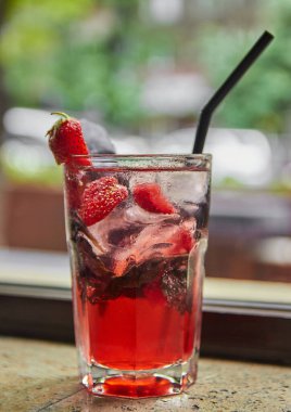 Buzlu çilek kokteyli ve ahşap bir masada nane şekeri.