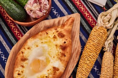 Tahta bir masada peynirli ve sebzeli pizza.