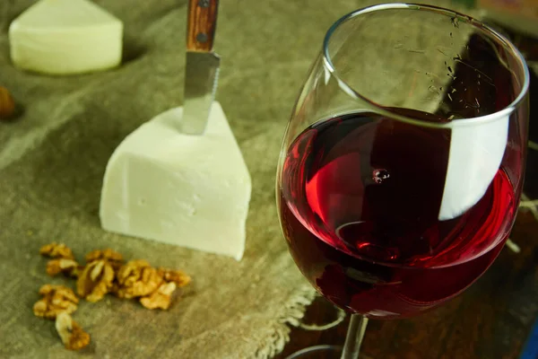 红葡萄酒和奶酪放在木制桌子上 — 图库照片