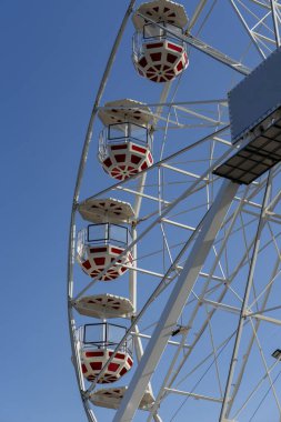 Mavi gökyüzüne karşı kırmızı ve beyaz dönme dolaplar