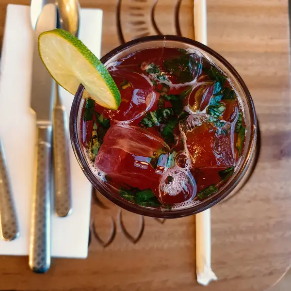 Tahta bir masada buzlu, limonlu ve naneli kokteyl.